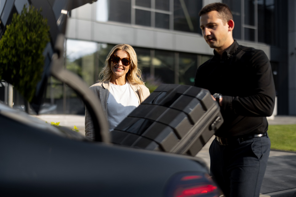 Chauffeur de taxi VTC à Paris prend en charge la valise d'une cliente